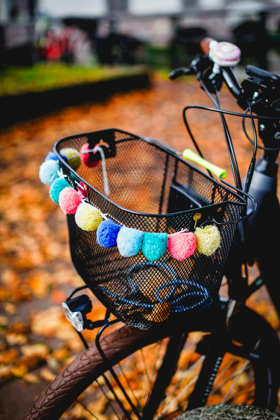 panier avant de vélo en métal noir et décoré d'une guirlande multicolore