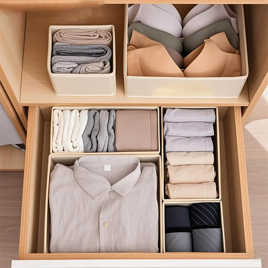 Paniers de rangement pliables en tissu beige, avec des vêtements pliés à l'intérieur, dans un tiroir