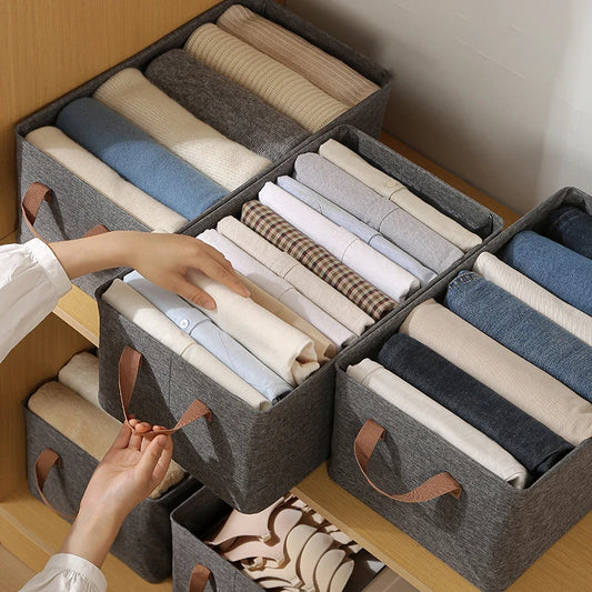 vêtements pliés dans boite de rangement en tissu gris, rectangulaire à poignées
